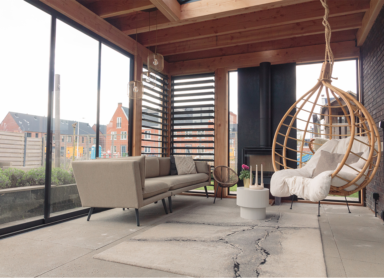 Loungebank en hangstoelen onder houten overkapping in Bodegraven