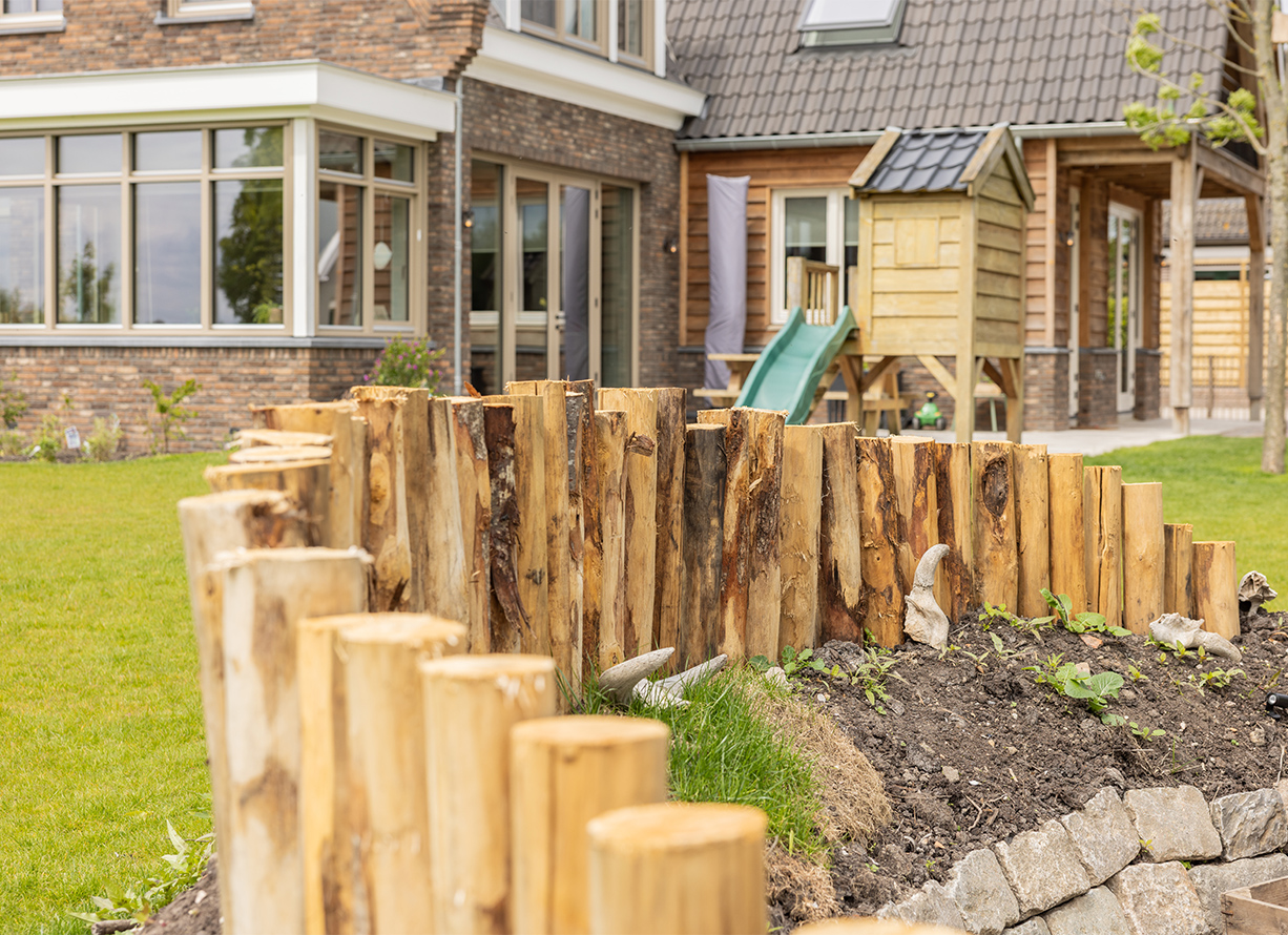 Tuin met houten palen en speeltoestel in Ouderkerk aan den IJssel