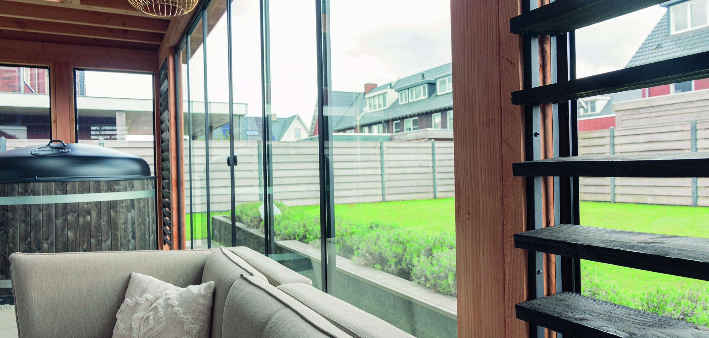 Loungebank in buitenverblijf met uitzicht op de tuin in Bodegraven