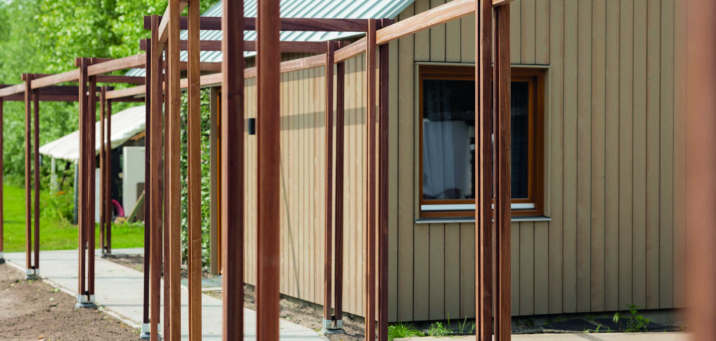 Pergola met tegelpad langs de schuur in Oud-Beijerland