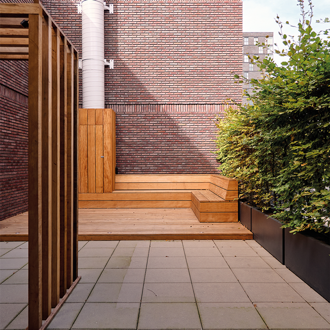 Houten zitelement met beplanting op dakterras in Rotterdam