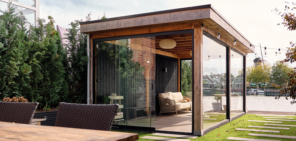 Buitenverblijf met overkapping aan het water in tuin aan de IJssel