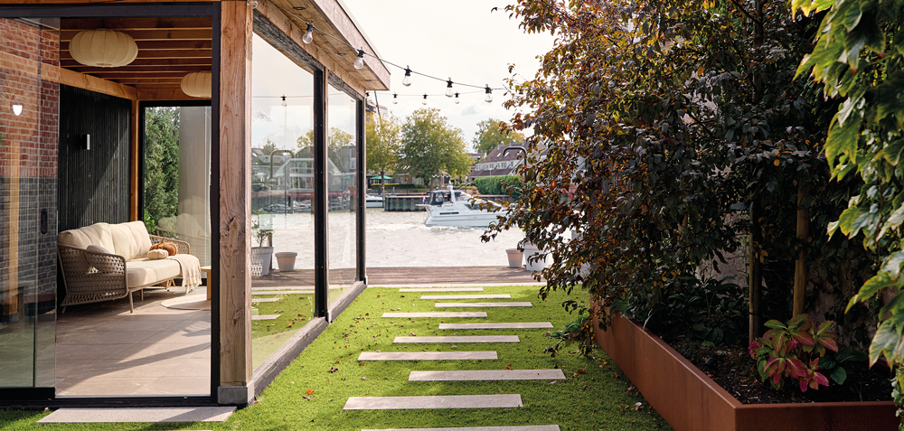 Buitenverblijf met stapstenen en borders in tuin aan de IJssel