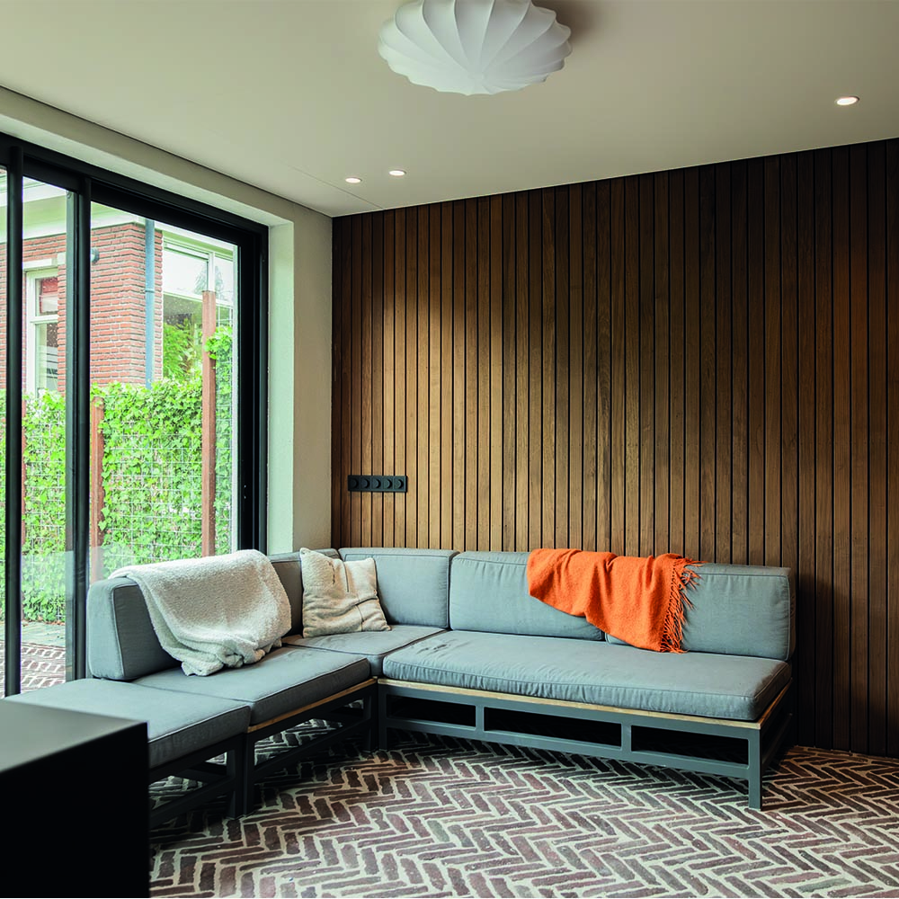 Loungehoek in buitenverblijf met houten wand in Rotterdam