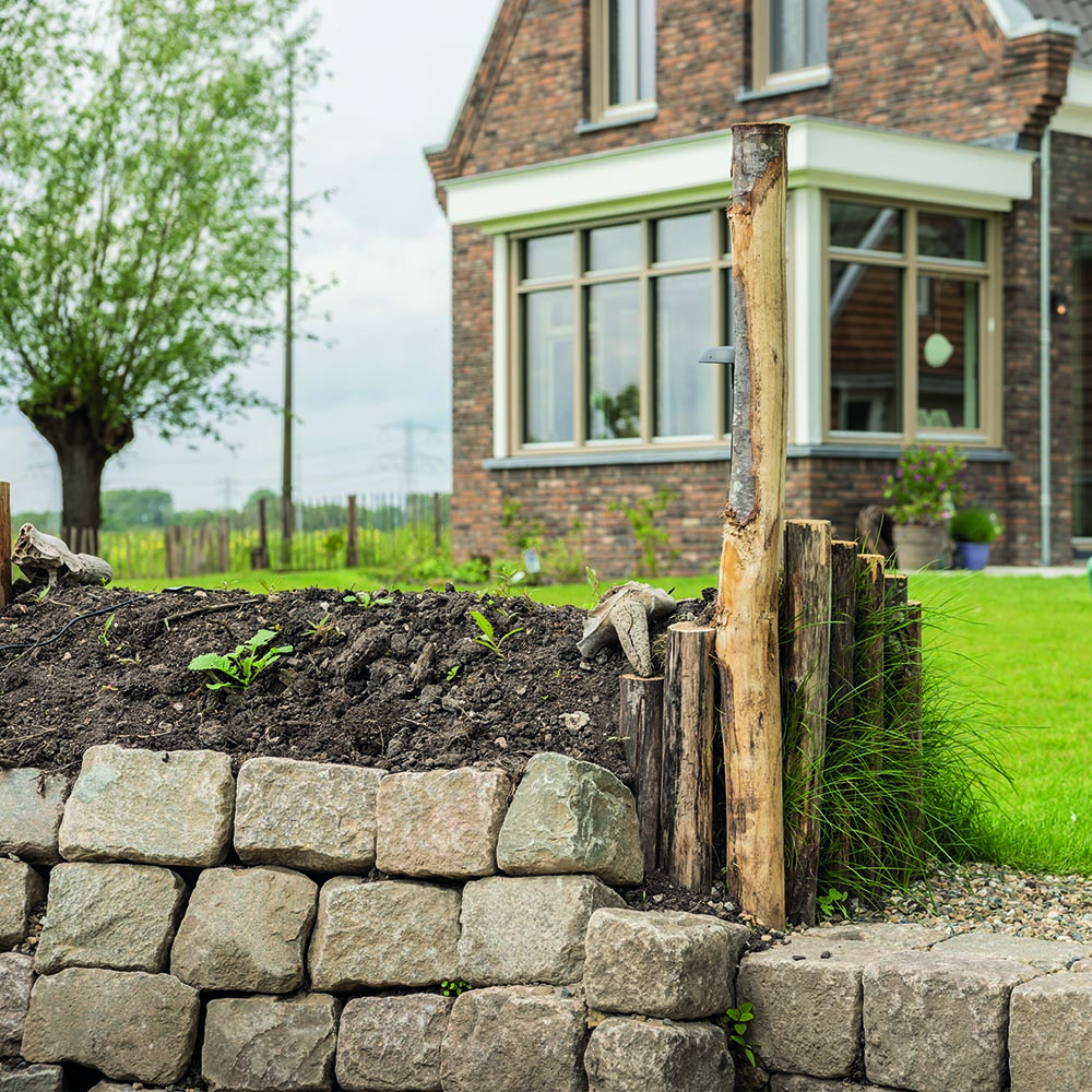 Natuurstenen keermuur met houten palen in Ouderkerk aan den IJssel