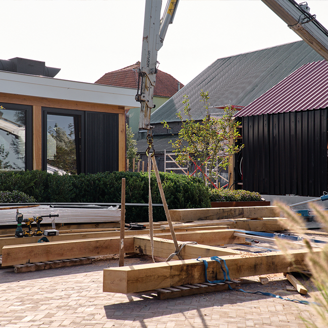 Buitenverblijf in aanbouw met houten balken in Waddinxveen