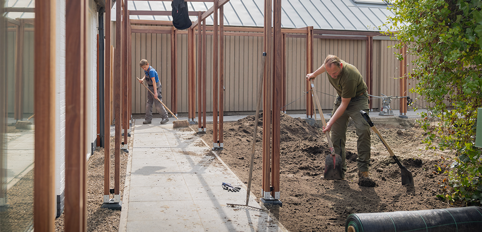 Vakmensen van Vida Garden aan het werk onder de pergola